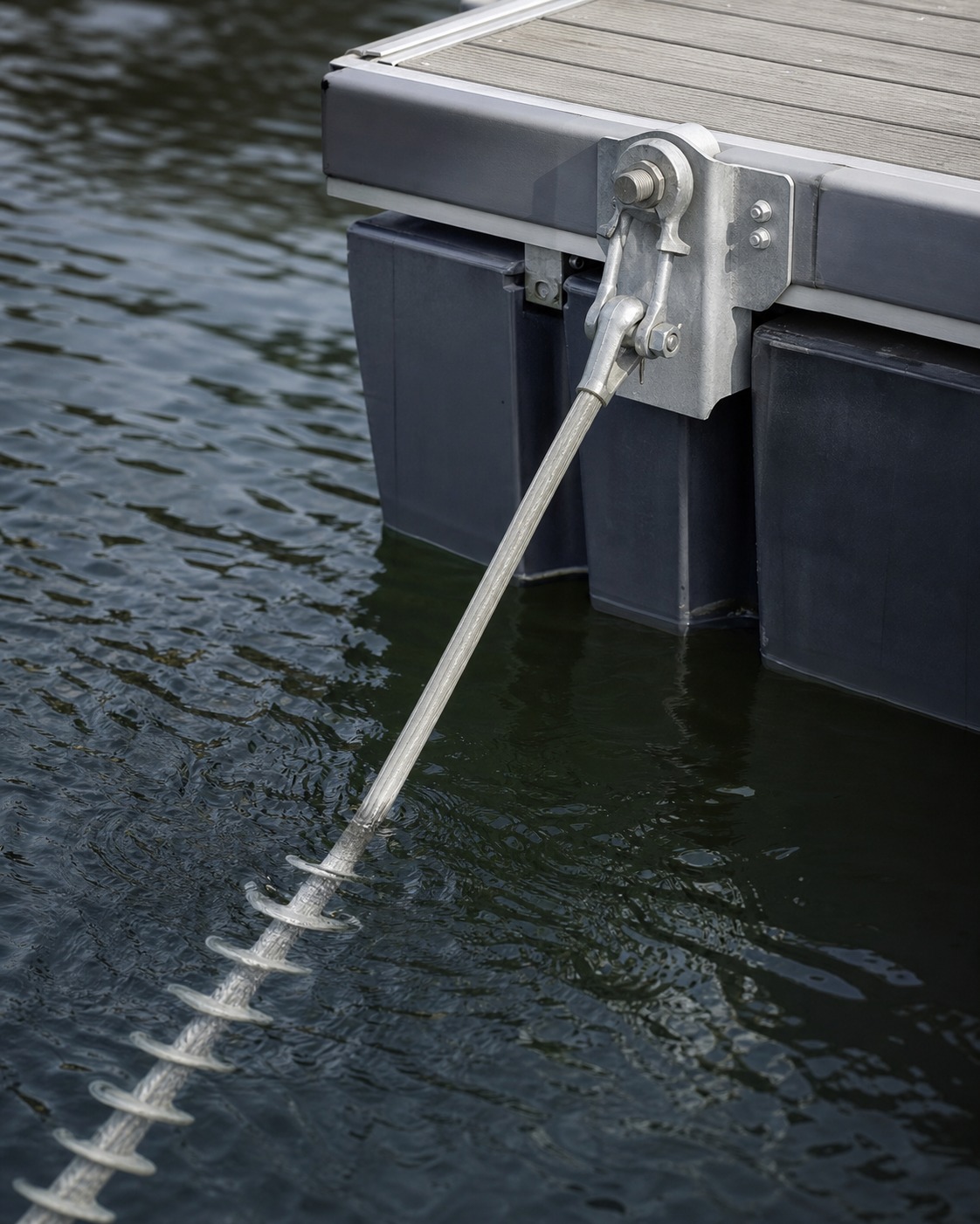 Helical anchor and tether line attached to the edge of a floating platform.