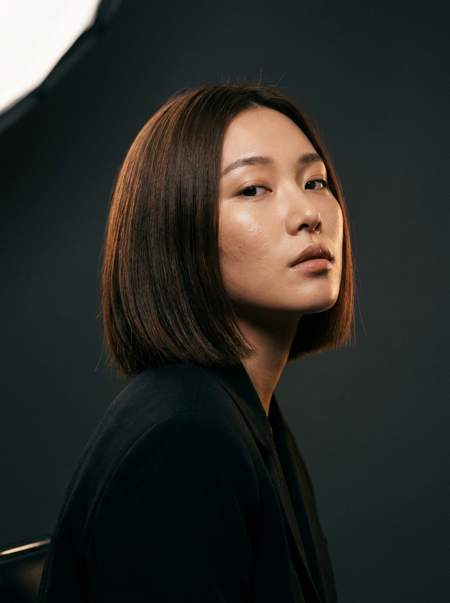 korean-hair-salon-design-hero-editorial-portrait Professional studio headshot of woman with bob haircut wearing dark blazer, soft lighting, neutral background. | Sky Rye Design Professional studio headshot of woman with bob haircut wearing dark blazer, soft lighting, neutral background.