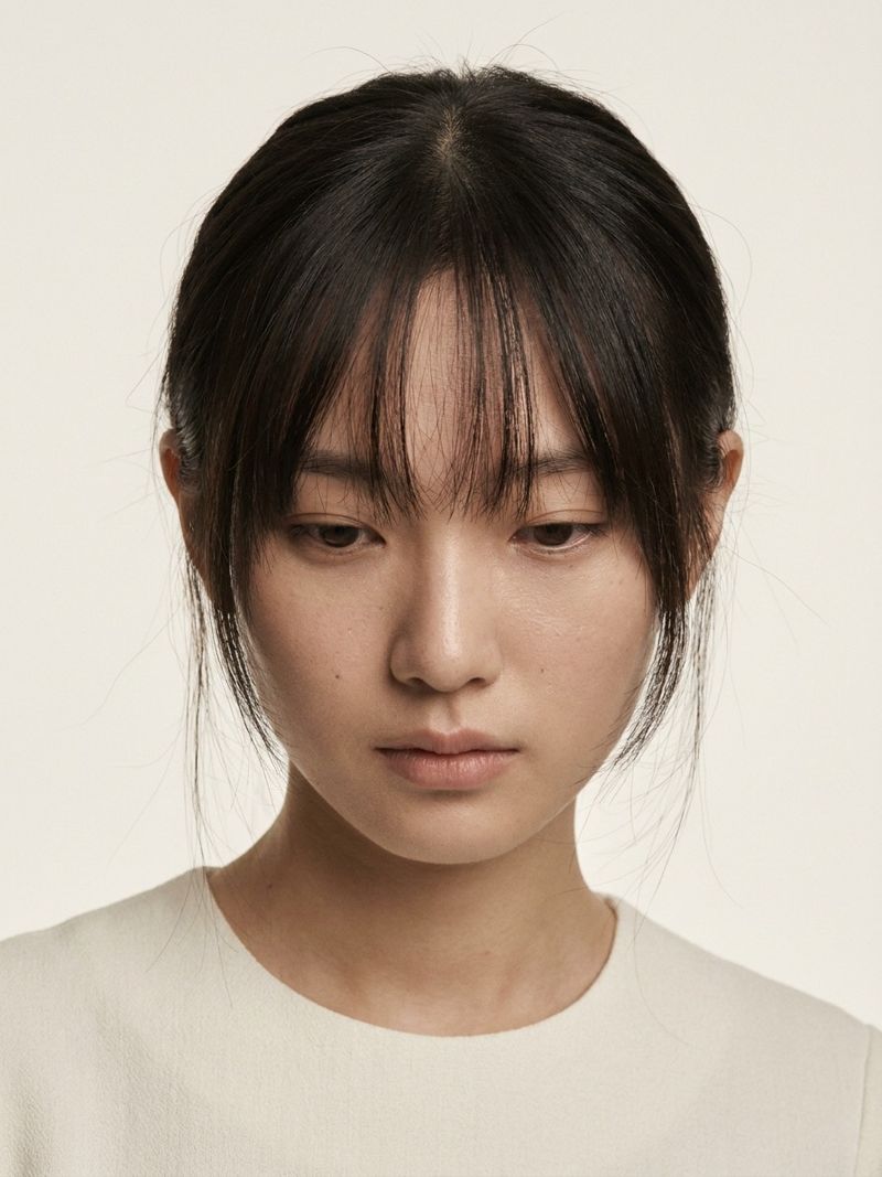 Close-up of fine see-through Korean bangs Close-up beauty shot of a model with fine see-through Korean bangs and soft centre-parted layers framing the eyes | Sky Rye Design Close-up beauty shot of a model with fine see-through Korean bangs and soft centre-parted layers framing the eyes