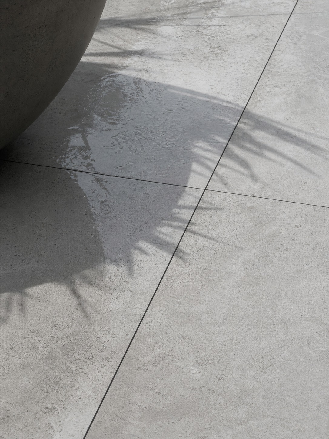 Large-format porcelain paver patio detail Close detail of large-format porcelain pavers with hairline joints and a sculptural planter shadow | Sky Rye Design Close detail of large-format porcelain pavers with hairline joints and a sculptural planter shadow