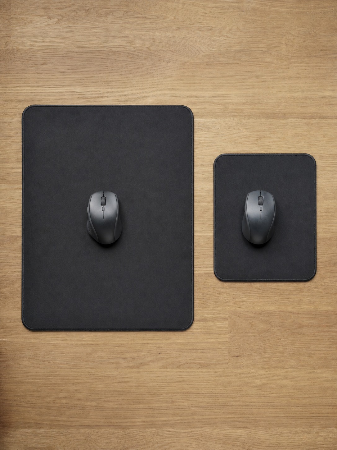 Large and compact gaming mousepads shown side by side with a mouse on each pad for scale
