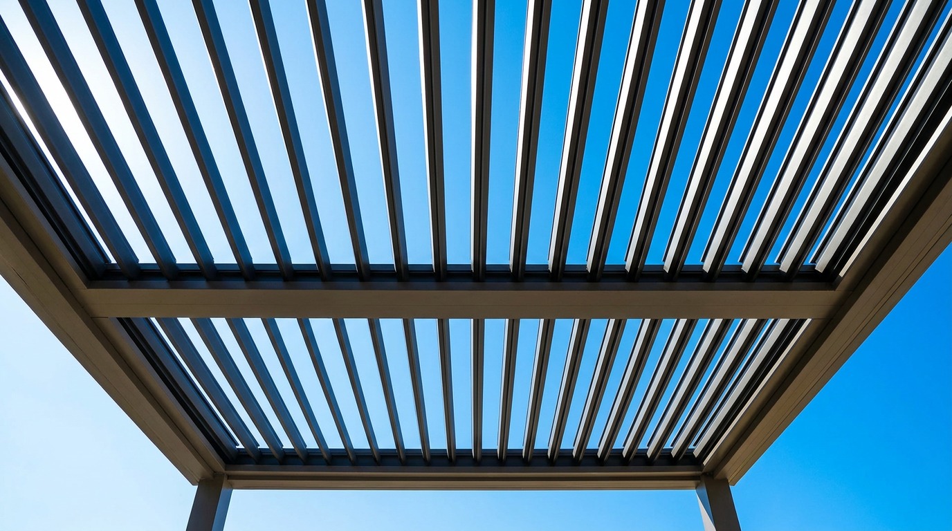 View looking up through a louvered pergola with blades rotated fully open to the sky