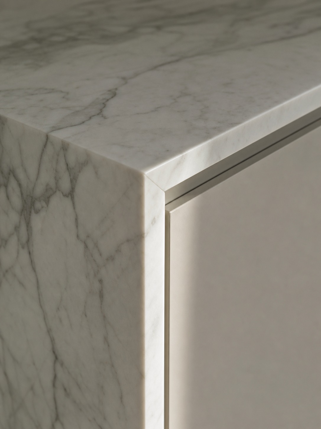 Marble waterfall island edge meeting flush cabinetry Close-up of a book-matched marble waterfall island edge meeting a flush cabinet face with a precise seam. | Sky Rye Design Close-up of a book-matched marble waterfall island edge meeting a flush cabinet face with a precise seam.