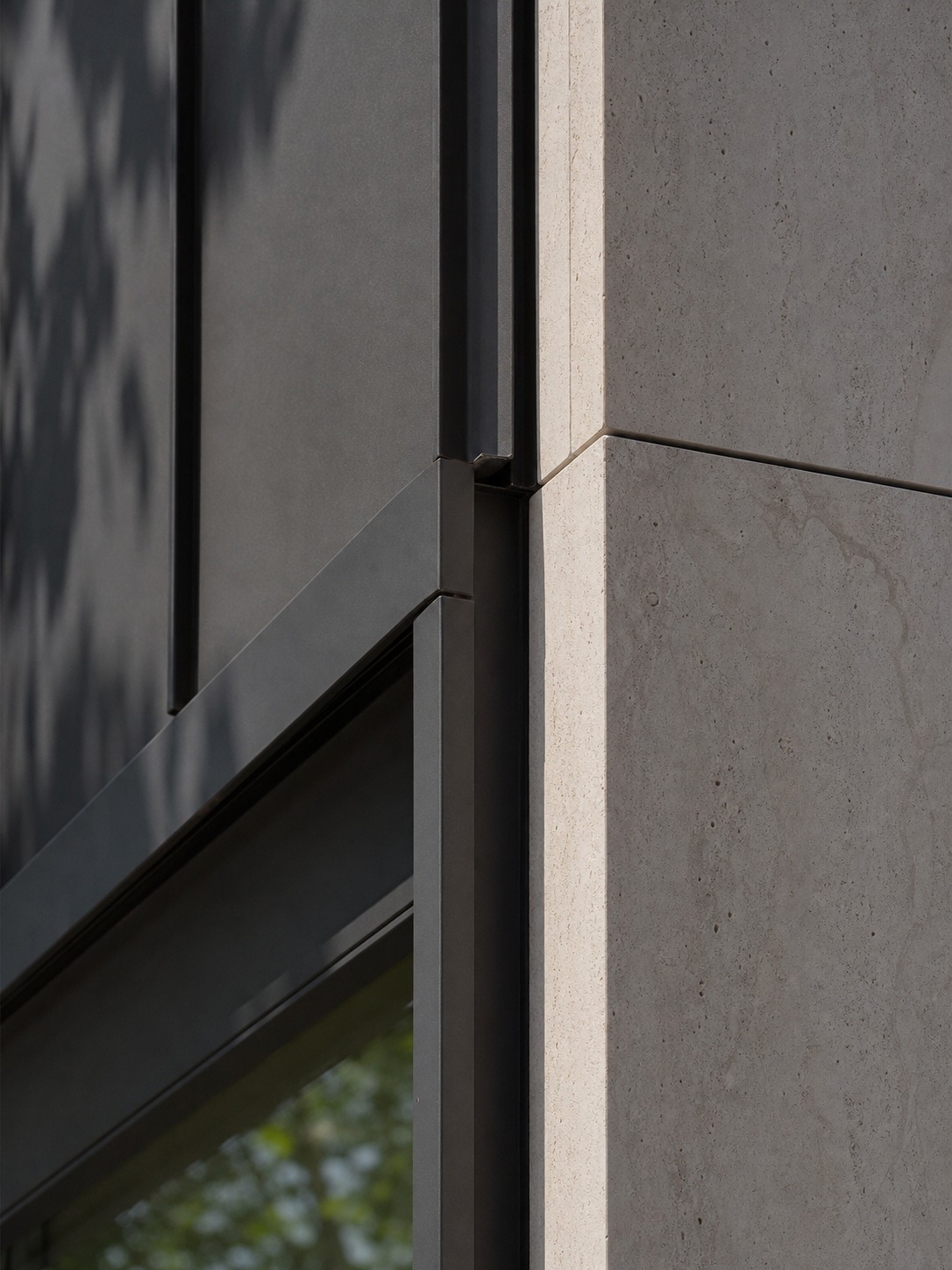 Metal and stone cladding corner reveal Detail of a building corner where dark metal cladding meets pale sintered stone panels. | Sky Rye Design Detail of a building corner where dark metal cladding meets pale sintered stone panels.