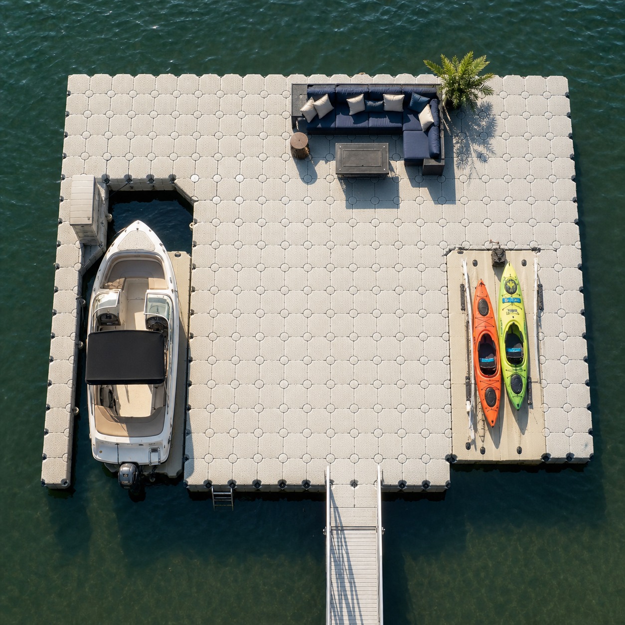Top-down view of a modular floating platform with boat mooring, lounging, and kayak zones.
