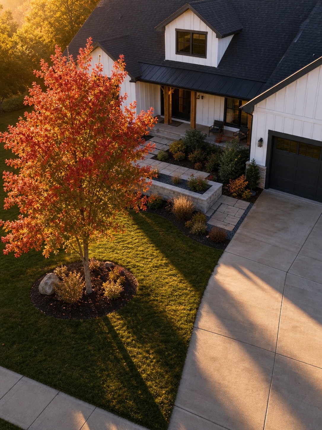 Elevated view of a front yard with a Chinese pistache tree placed off-center near a driveway.