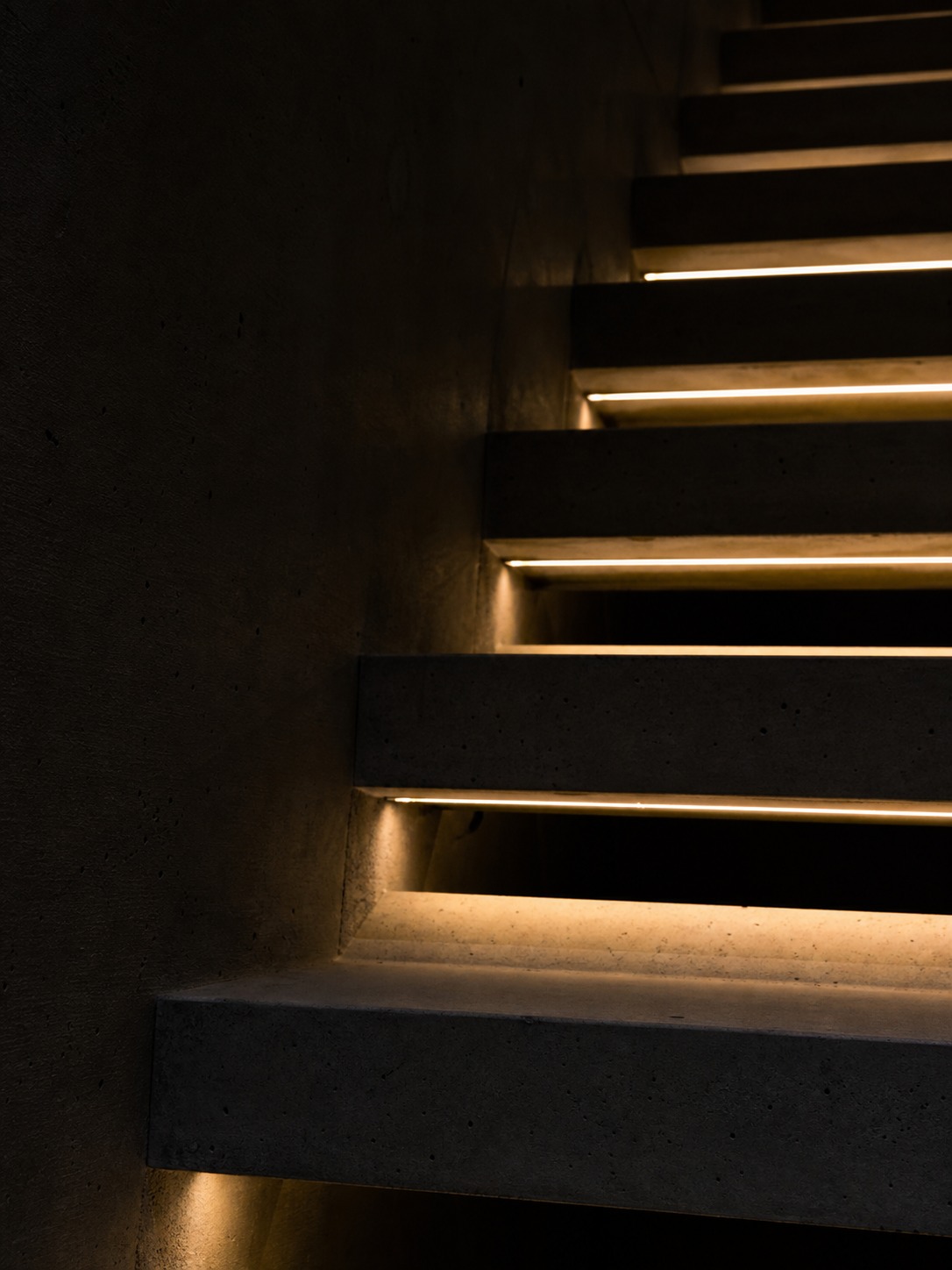 Concrete stair lighting with linear LEDs Floating concrete stair with recessed linear LED channels under each tread at night | Sky Rye Design Floating concrete stair with recessed linear LED channels under each tread at night