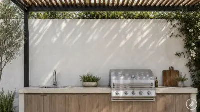 Backyard outdoor kitchen with modern stainless steel gas grill, sink, wooden cabinets under a pergola