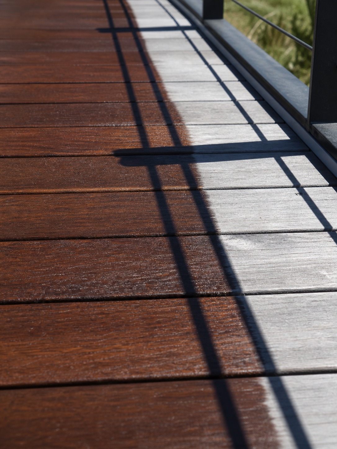 Restored ipe deck flooring detail Close architectural detail of ipe decking showing restored rich wood beside weathered gray boards | Sky Rye Design Close architectural detail of ipe decking showing restored rich wood beside weathered gray boards