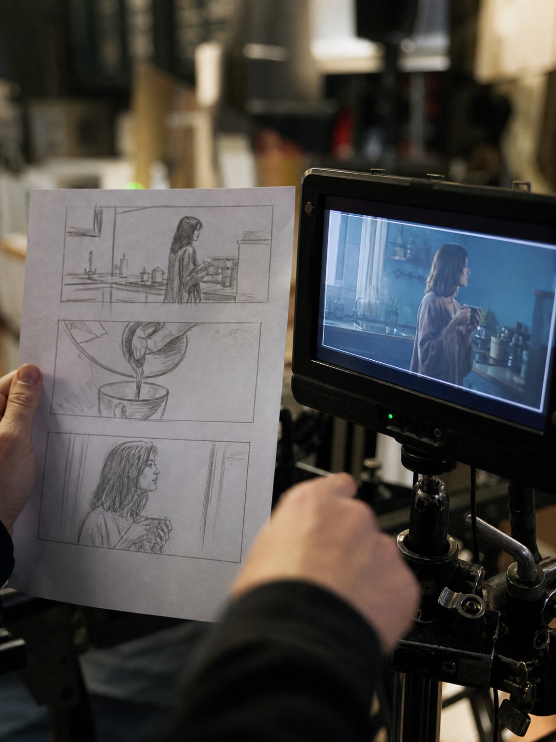 Storyboard review beside camera monitor Hands compare a printed storyboard with live camera monitor framing on set. | Sky Rye Design Hands compare a printed storyboard with live camera monitor framing on set.