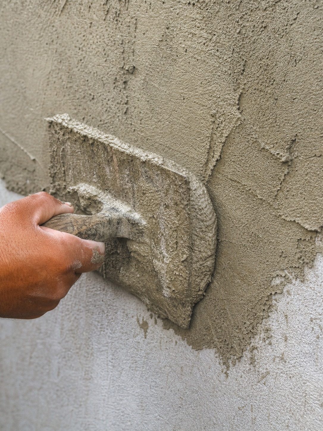 Stucco coating trowel application Close-up of a trowel applying fresh stucco coating to an exterior wall. | Sky Rye Design Close-up of a trowel applying fresh stucco coating to an exterior wall.