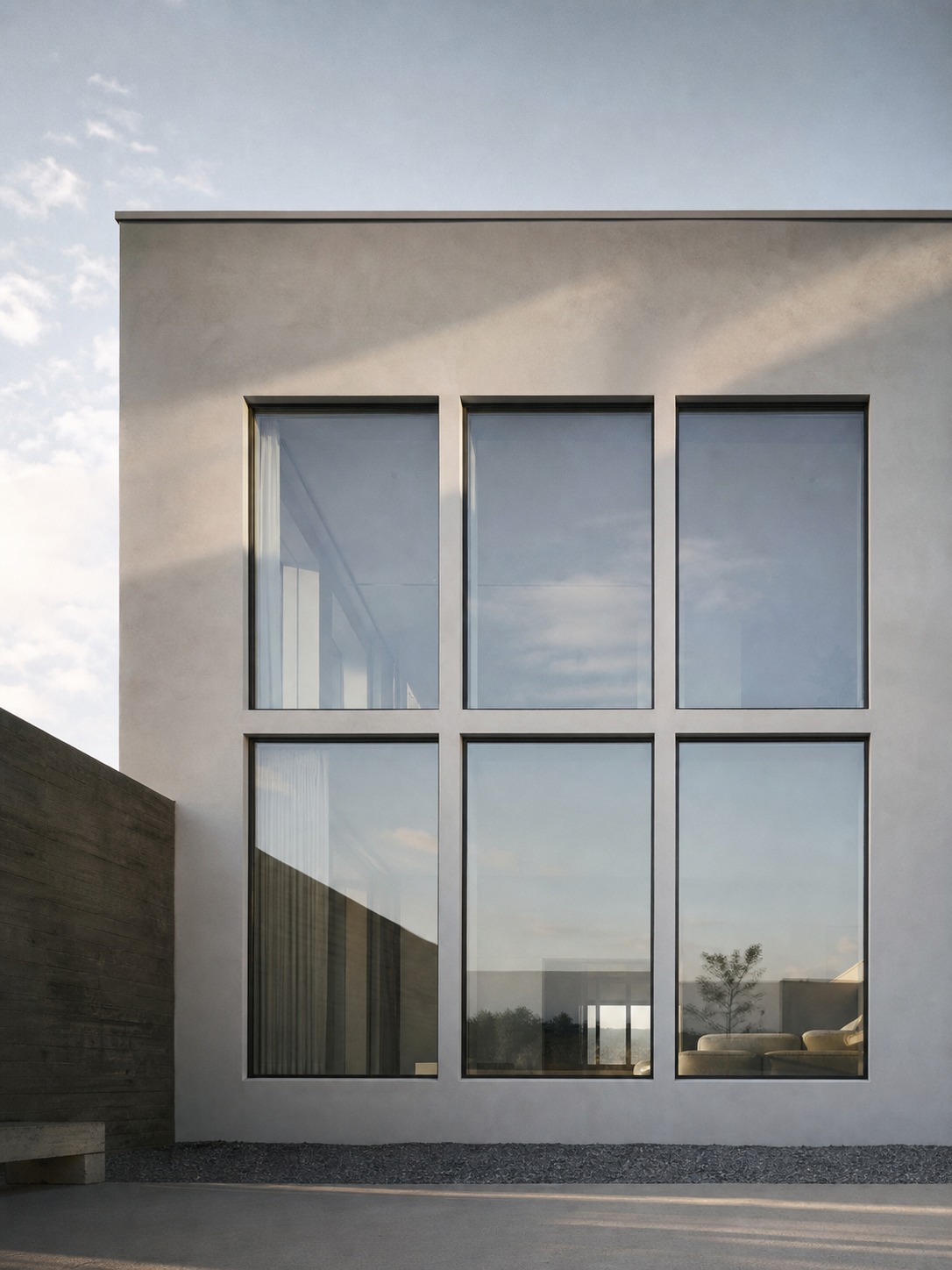 Ultra-modern house facade with a precise grid of large flush-glazed windows in a minimal plaster wall.