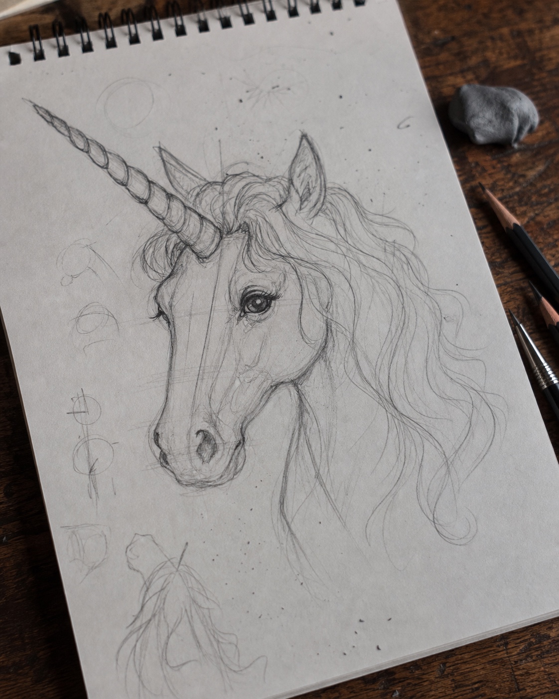 Unicorn head sketchbook process Pencil sketchbook study of a unicorn head with construction lines, spiral horn, flowing mane, and graphite texture. | Sky Rye Design Pencil sketchbook study of a unicorn head with construction lines, spiral horn, flowing mane, and graphite texture.