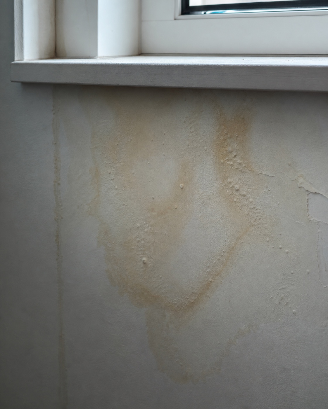 Water stain below a window sill Water stain and bubbled paint on an interior wall below a window sill. | Sky Rye Design Water stain and bubbled paint on an interior wall below a window sill.