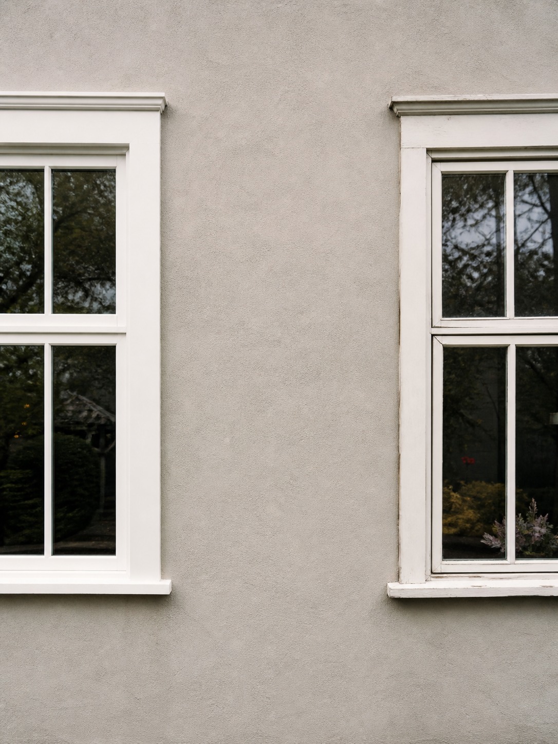 Two adjacent facade sections comparing crisp window framing with slightly warped and dated framing.