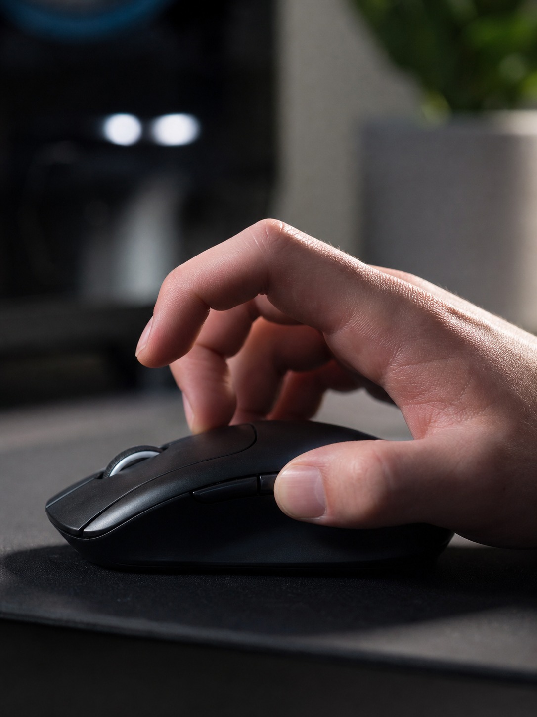 Hand using a claw grip on a wireless gaming mouse with arched fingers