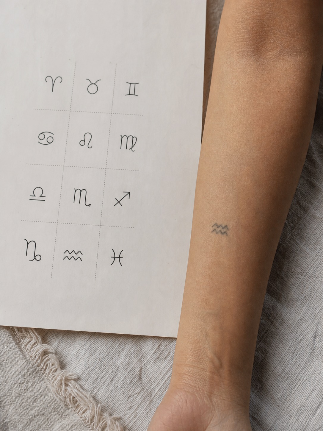 Zodiac glyph scale comparison beside a healed small tattoo A reference sheet showing a fine-line zodiac glyph beside a slightly blurred healed tattoo at small scale. | Sky Rye Design A reference sheet showing a fine-line zodiac glyph beside a slightly blurred healed tattoo at small scale.