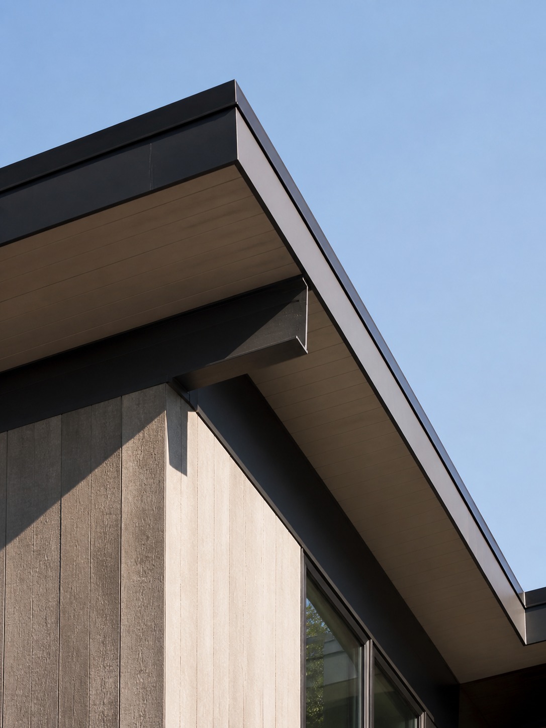 Roof as architectural silhouette Modern roofline photographed from below, showing crisp eave geometry and shadow lines against a clear sky. | Sky Rye Design Modern roofline photographed from below, showing crisp eave geometry and shadow lines against a clear sky.