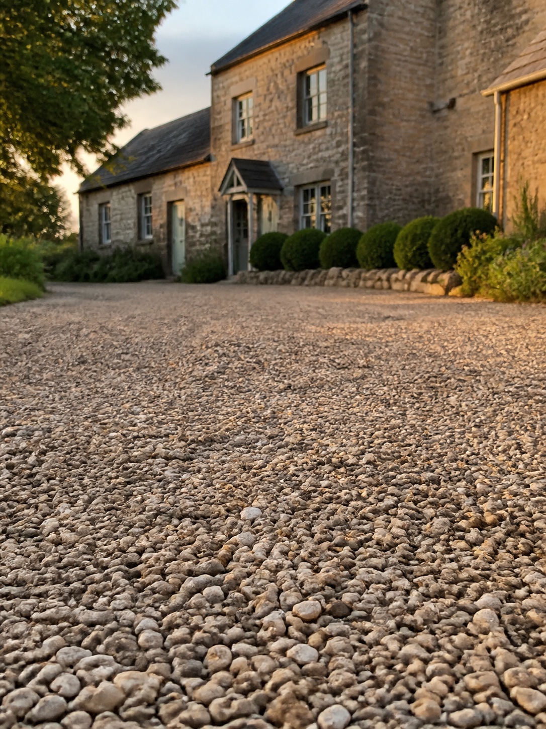 Driveway design idea - Gravel driveway texture close-up Close view of natural gravel driveway texture with a farmhouse softly in the background | Sky Rye Design Close view of natural gravel driveway texture with a farmhouse softly in the background