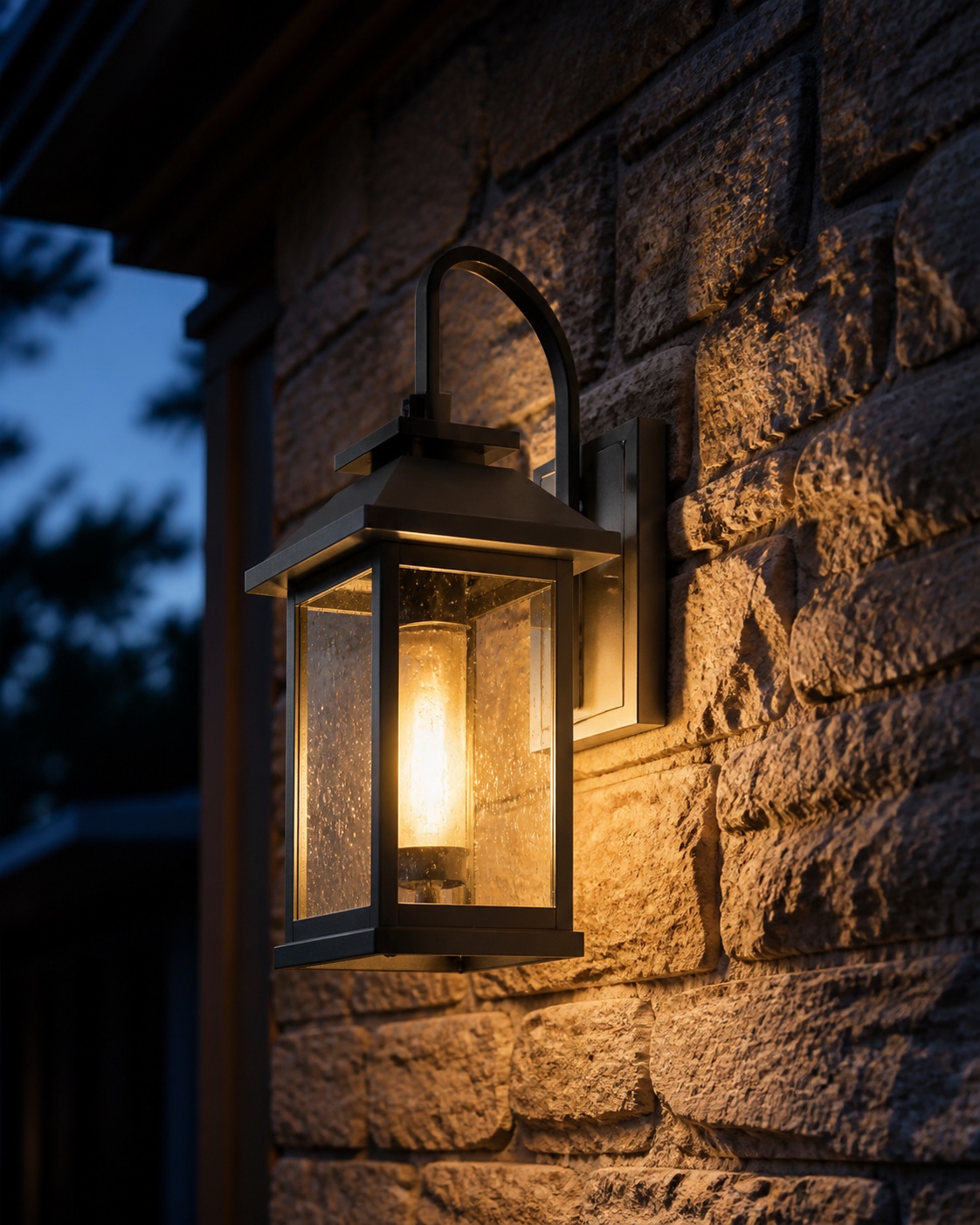 Ambient wall lantern glow on a stone entry Wall-mounted lantern casting soft warm ambient light across a textured stone exterior wall. | Sky Rye Design Wall-mounted lantern casting soft warm ambient light across a textured stone exterior wall.