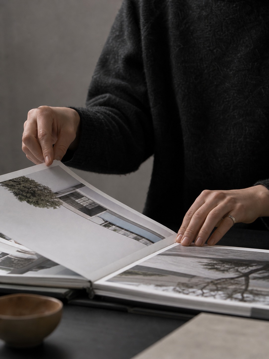 Architect turning a printed portfolio page during a quiet review