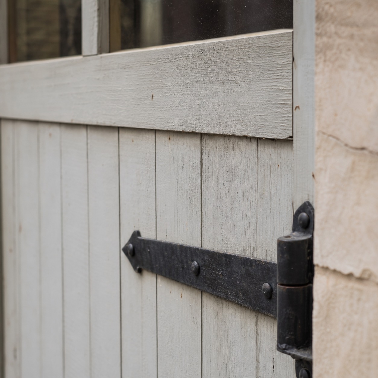 Board-and-batten farmhouse front door detail Close view of a board-and-batten farmhouse front door with painted wood grain and matte black iron hardware. | Sky Rye Design Close view of a board-and-batten farmhouse front door with painted wood grain and matte black iron hardware.