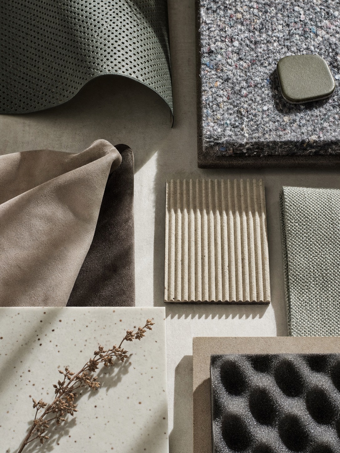 Acoustic fabric and sound-dampening material samples arranged for an EV interior review.