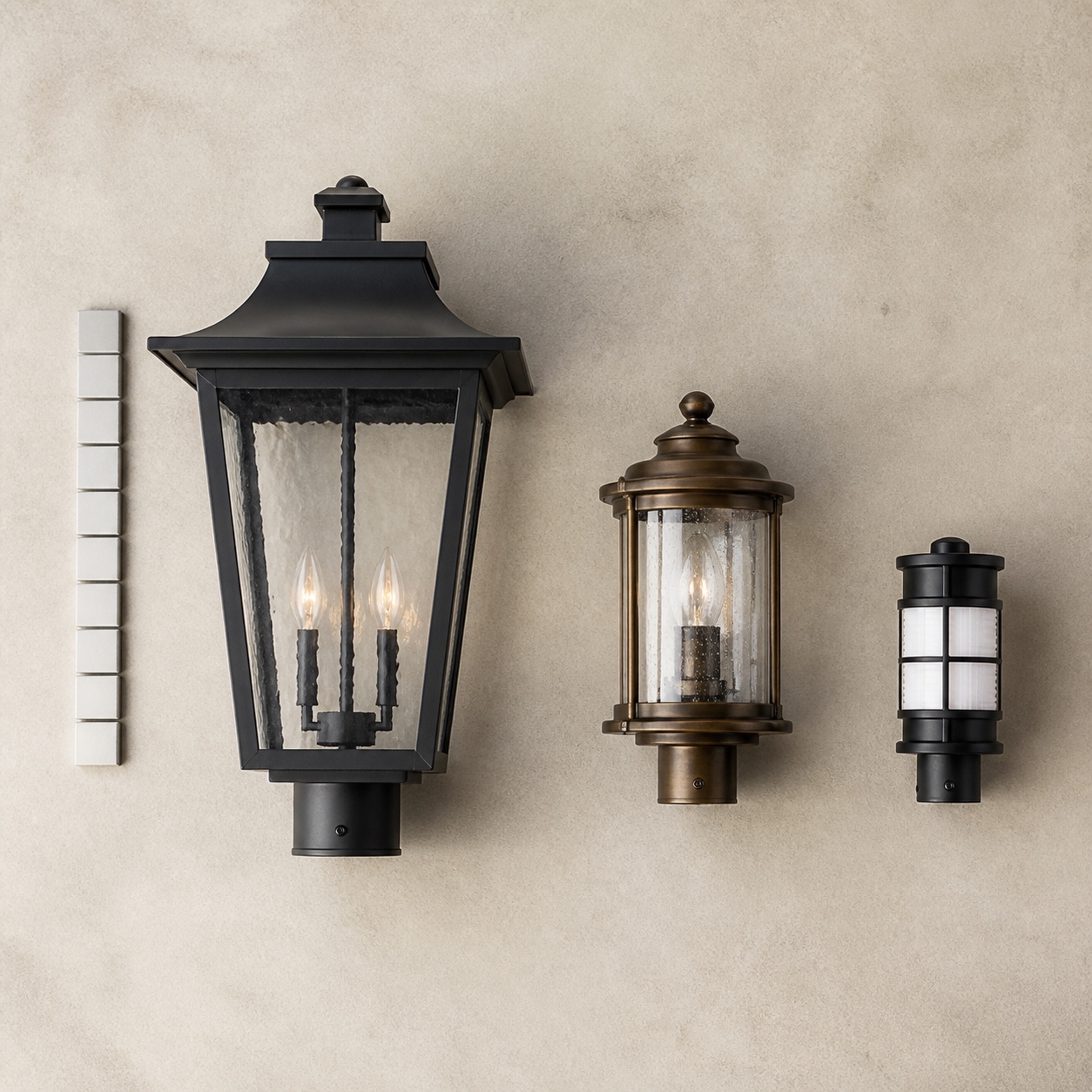 Exterior fixture scale comparison Three exterior light fixtures in different sizes= Three exterior light fixtures in different sizes arranged on a neutral surface with a scale reference.
