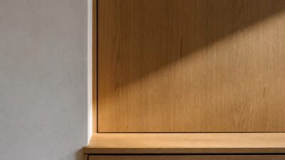 Completed millwork corner with precise reveal lines and natural light across the wood surface.