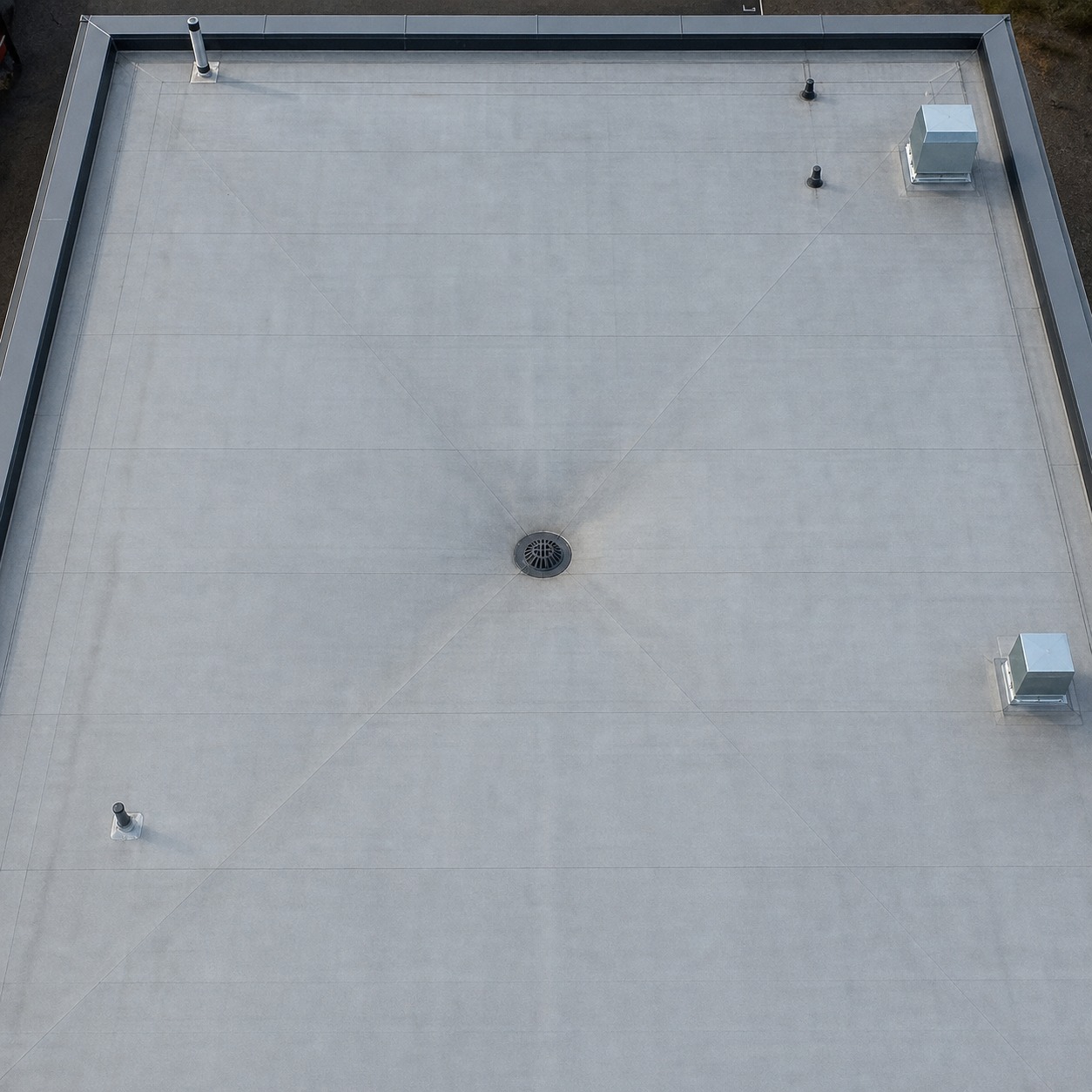Flat Roof Slope Lines Toward a Central Outlet Overhead view of a flat roof surface sloping subtly toward a central outlet. | Sky Rye Design Overhead view of a flat roof surface sloping subtly toward a central outlet.