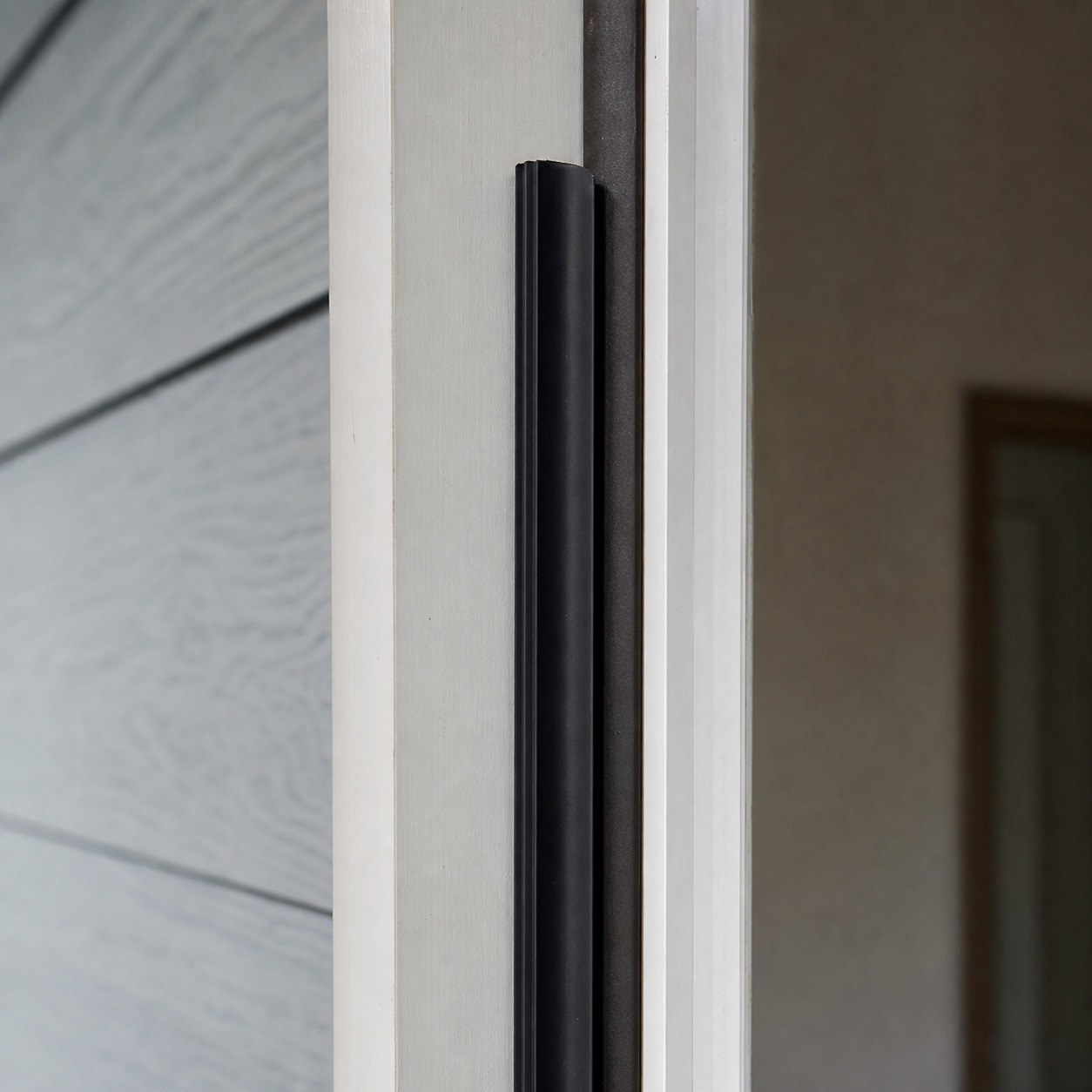 Front door weatherstripping and jamb detail Fresh weatherstripping applied evenly along a painted front door jamb in a close detail view. | Sky Rye Design Fresh weatherstripping applied evenly along a painted front door jamb in a close detail view.