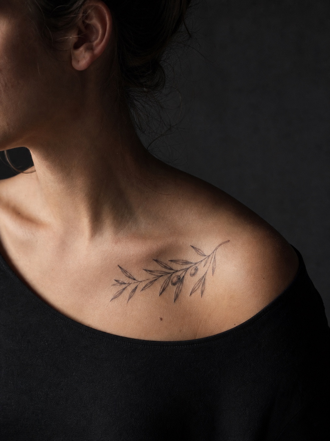 Olive branch collarbone tattoo Fine-line olive branch tattoo near the collarbone with narrow leaves and small olives. | Sky Rye Design Fine-line olive branch tattoo near the collarbone with narrow leaves and small olives.