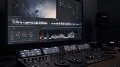 A dim color grading suite with a calibrated monitor and editing control surface.