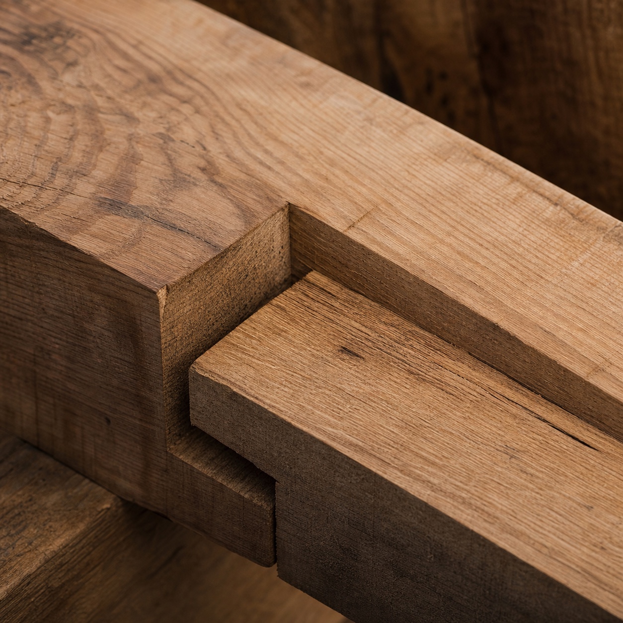 Stop-splayed scarf joint detail in a timber beam Close-up of a stop-splayed scarf joint showing stepped angled cut faces and visible timber grain. | Sky Rye Design Close-up of a stop-splayed scarf joint showing stepped angled cut faces and visible timber grain.