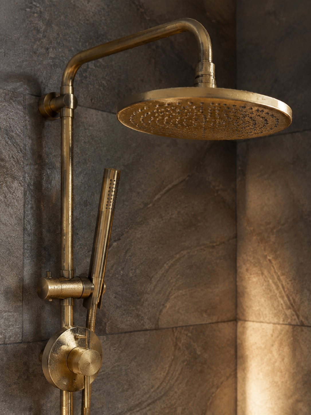 Brushed Brass Low Flow Shower Fixture Brushed brass low-flow shower fixture with water droplets catching the light. | Sky Rye Design Brushed brass low-flow shower fixture with water droplets catching the light.