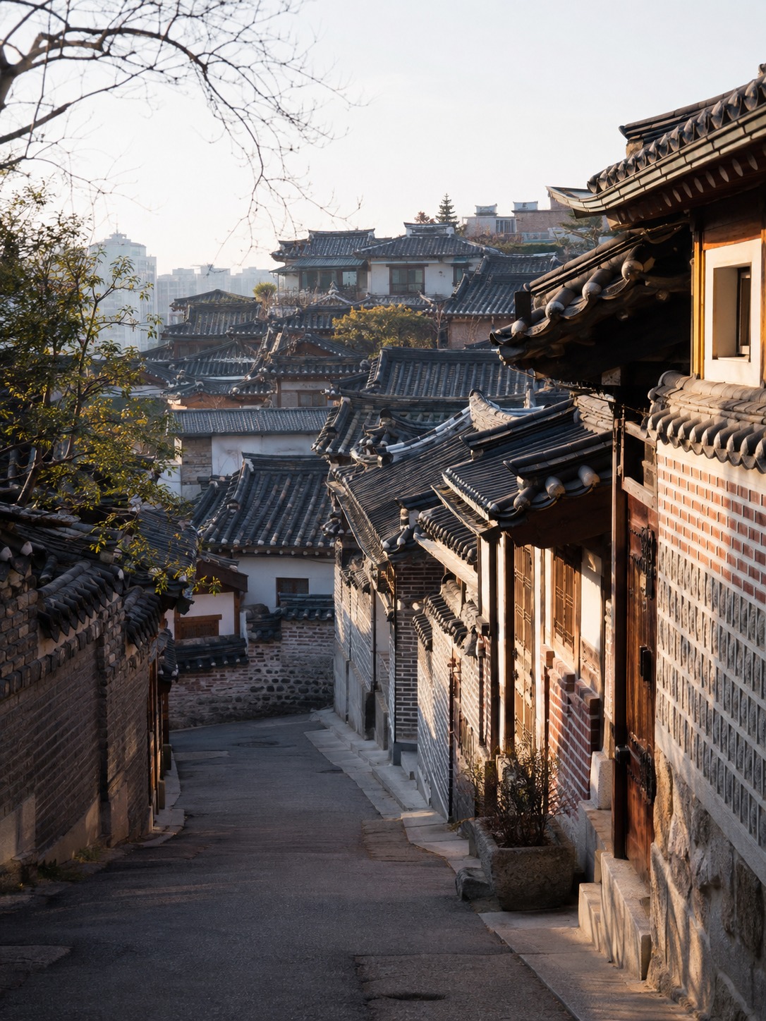 Bukchon Hanok Village street lined with traditional tiled-roof houses on a hillside.