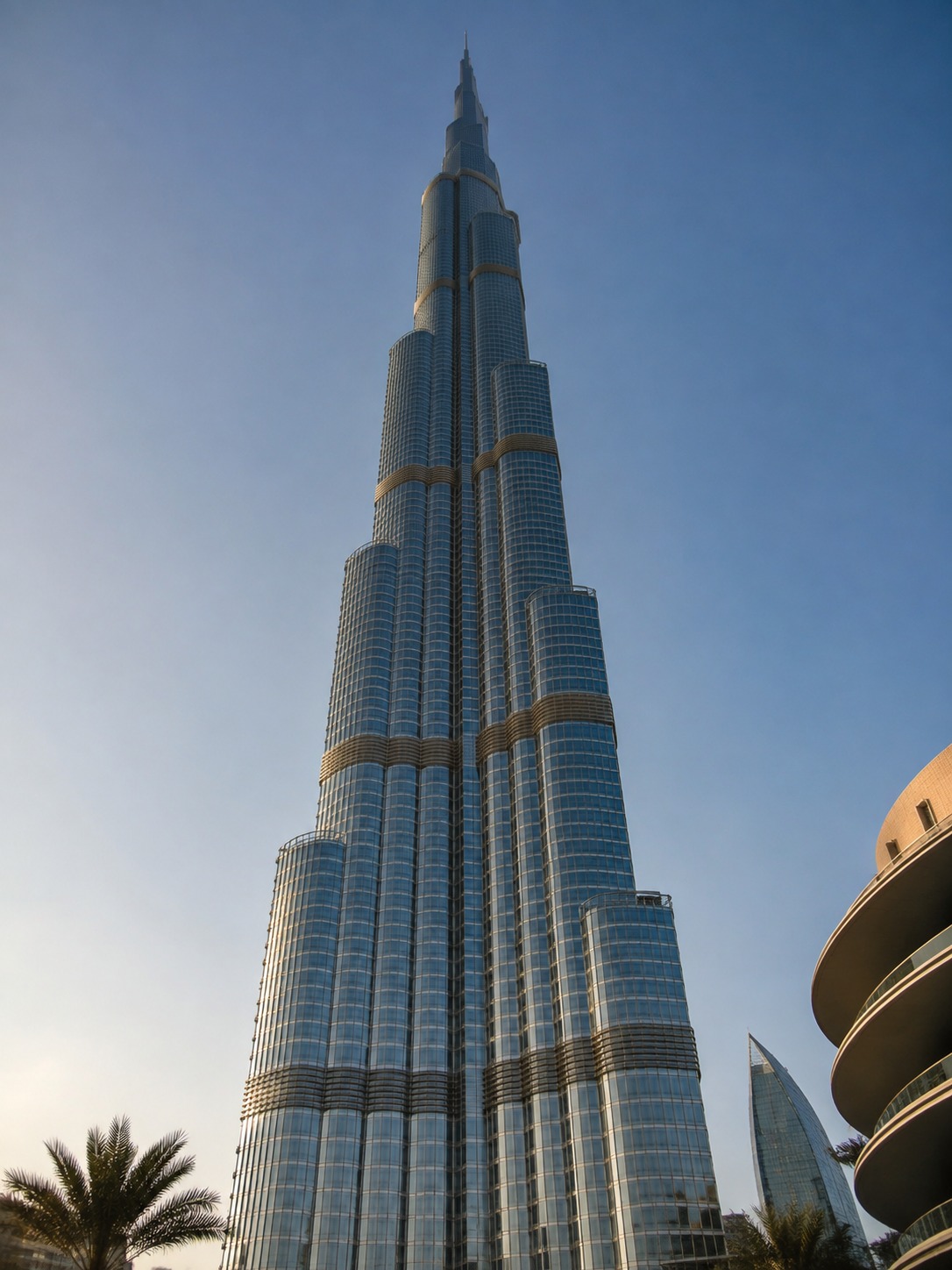 Ground-level view up Burj Khalifa showing its tapered buttressed form against the sky.