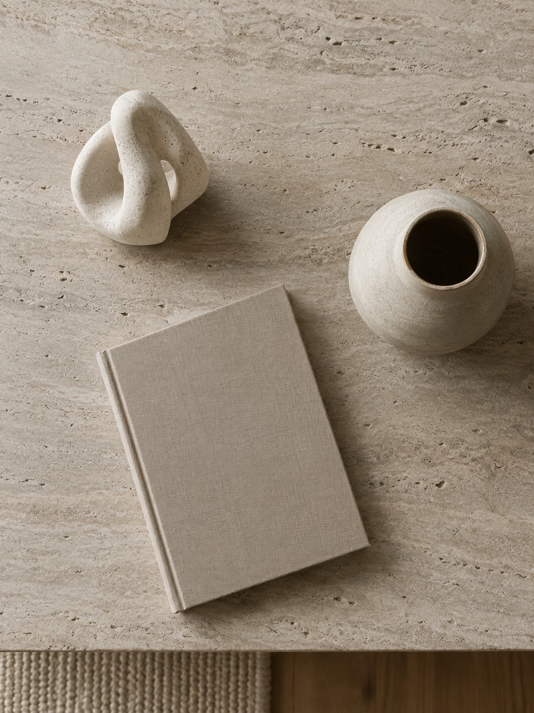 Curated console vignette with a sculpture, ceramic vessel, and single book