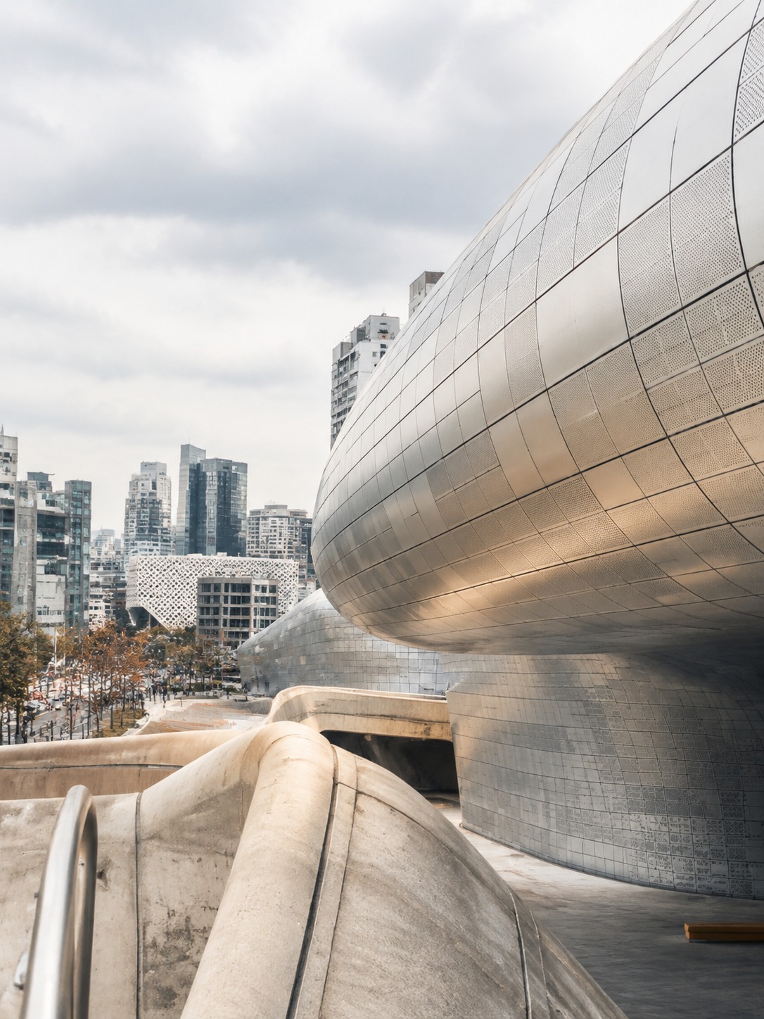 Dongdaemun Design Plaza curved metal exterior against the Seoul urban backdrop.