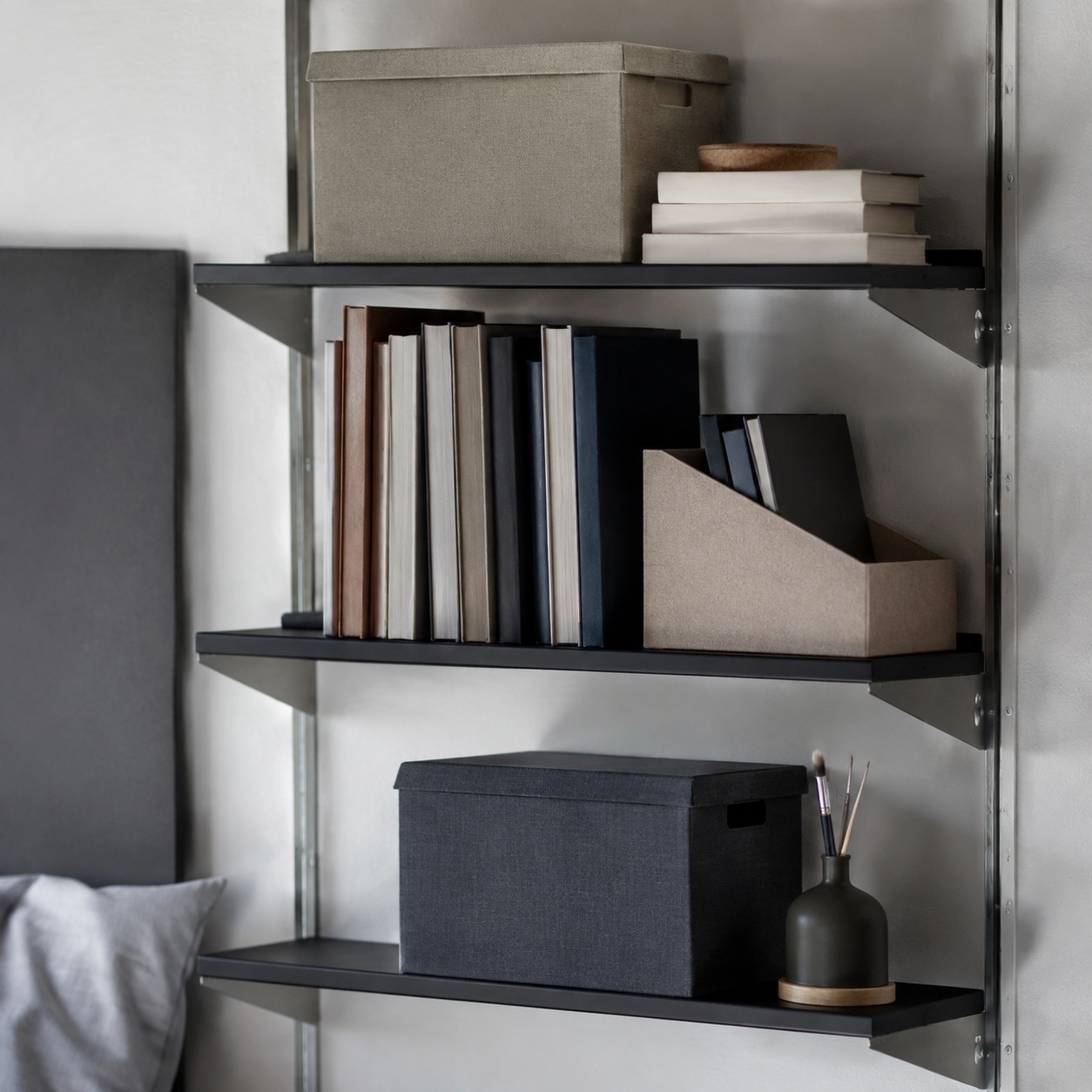 Dorm wall shelving with books and storage Wall-mounted shelving in a dorm room holding books and storage boxes. | Sky Rye Design Wall-mounted shelving in a dorm room holding books and storage boxes.