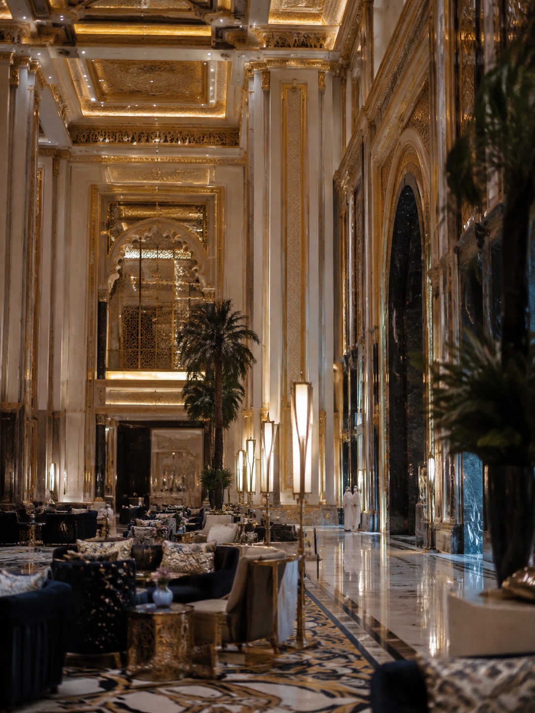 Ornate Dubai hotel lobby with marble, gold detailing, and layered lighting.