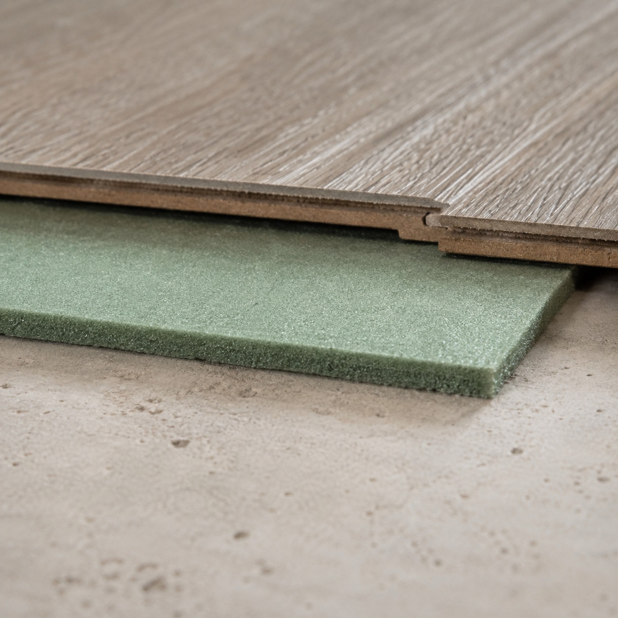 Flooring Underlayment Layer Detail A close cross-section detail of flooring underlayment beneath a wood-look plank. | Sky Rye Design A close cross-section detail of flooring underlayment beneath a wood-look plank.