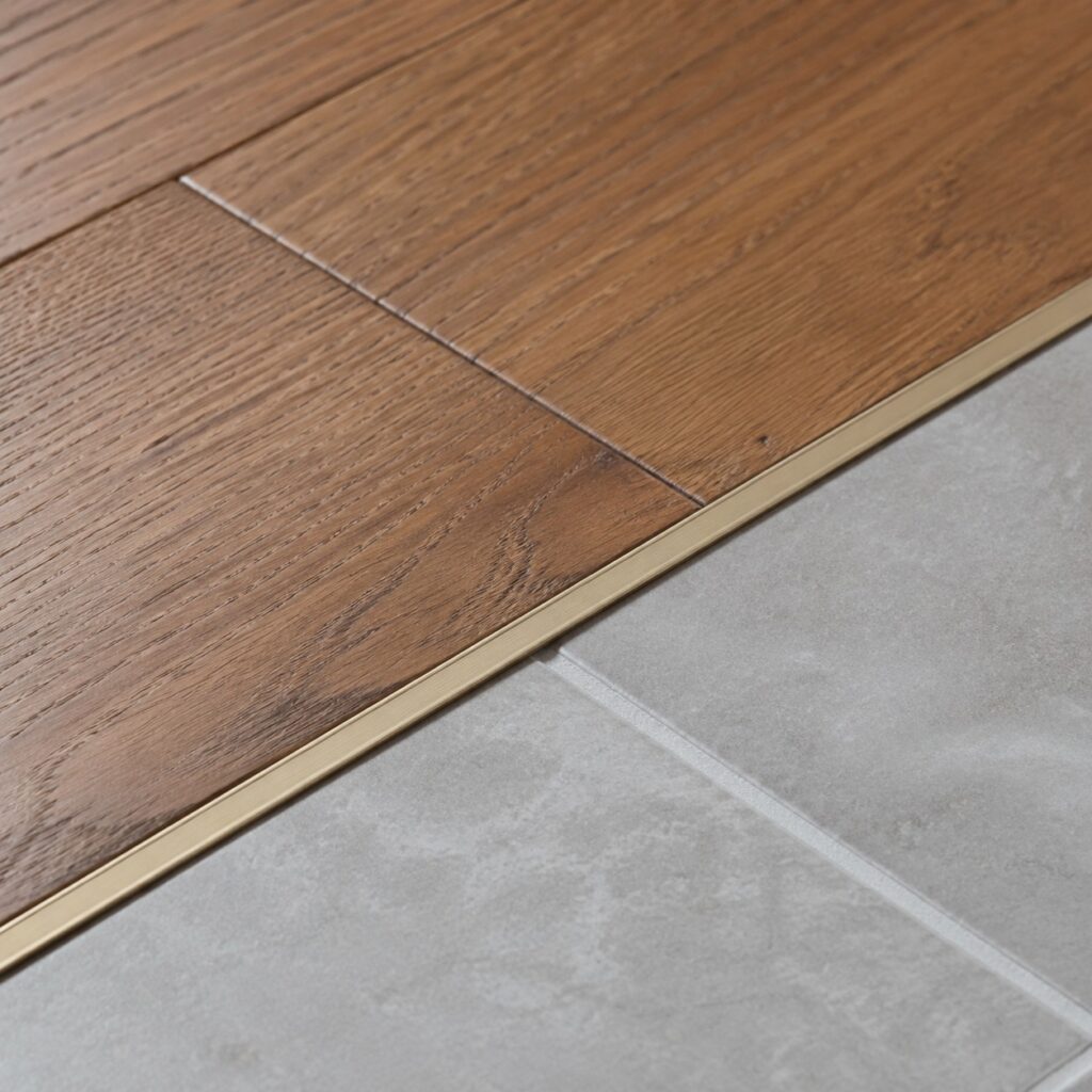 Hardwood to Tile Transition Strip Detail A clean transition strip between warm hardwood flooring and cool grey tile. | Sky Rye Design A clean transition strip between warm hardwood flooring and cool grey tile.