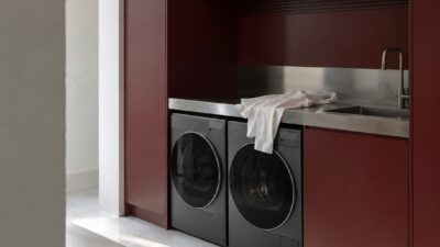 Burgundy laundry cabinetry with graphite appliances and a stainless-steel counter