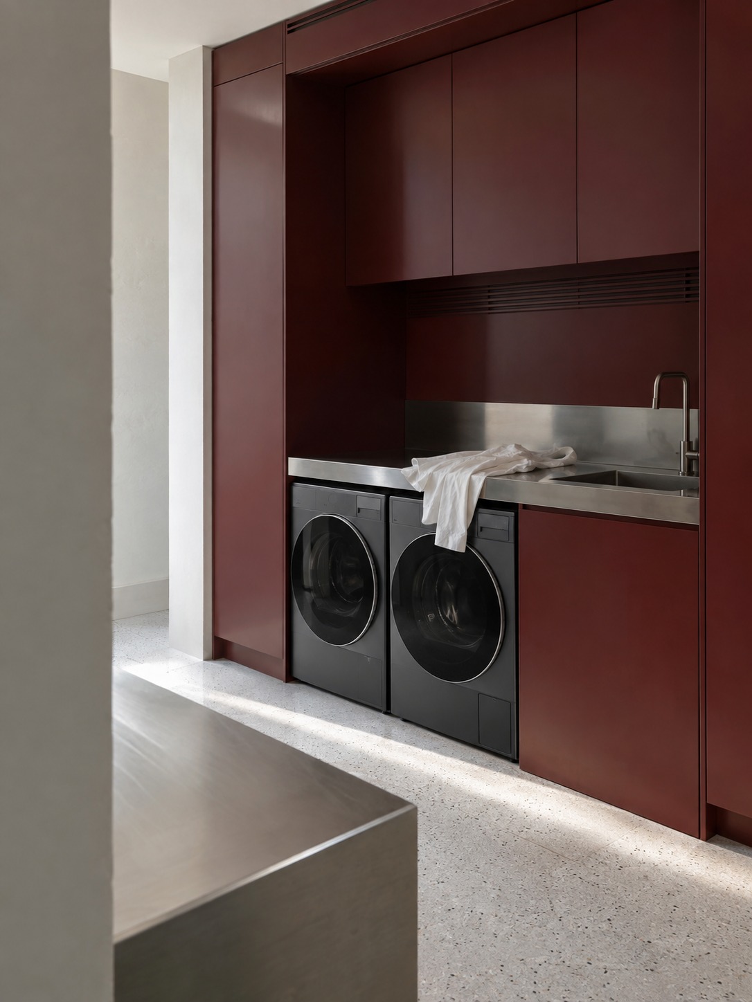 Oxblood laundry room Burgundy laundry cabinetry with graphite appliances and a stainless-steel counter | Sky Rye Design Burgundy laundry cabinetry with graphite appliances and a stainless-steel counter