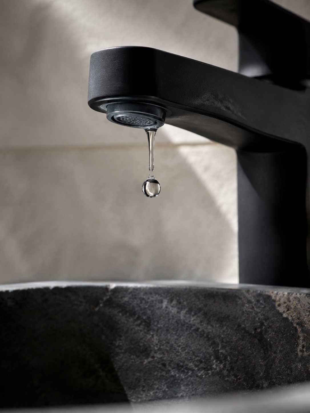 Matte Black Low Flow Faucet Aerator Detail Matte black low-flow faucet with a visible aerator and a falling water droplet. | Sky Rye Design Matte black low-flow faucet with a visible aerator and a falling water droplet.