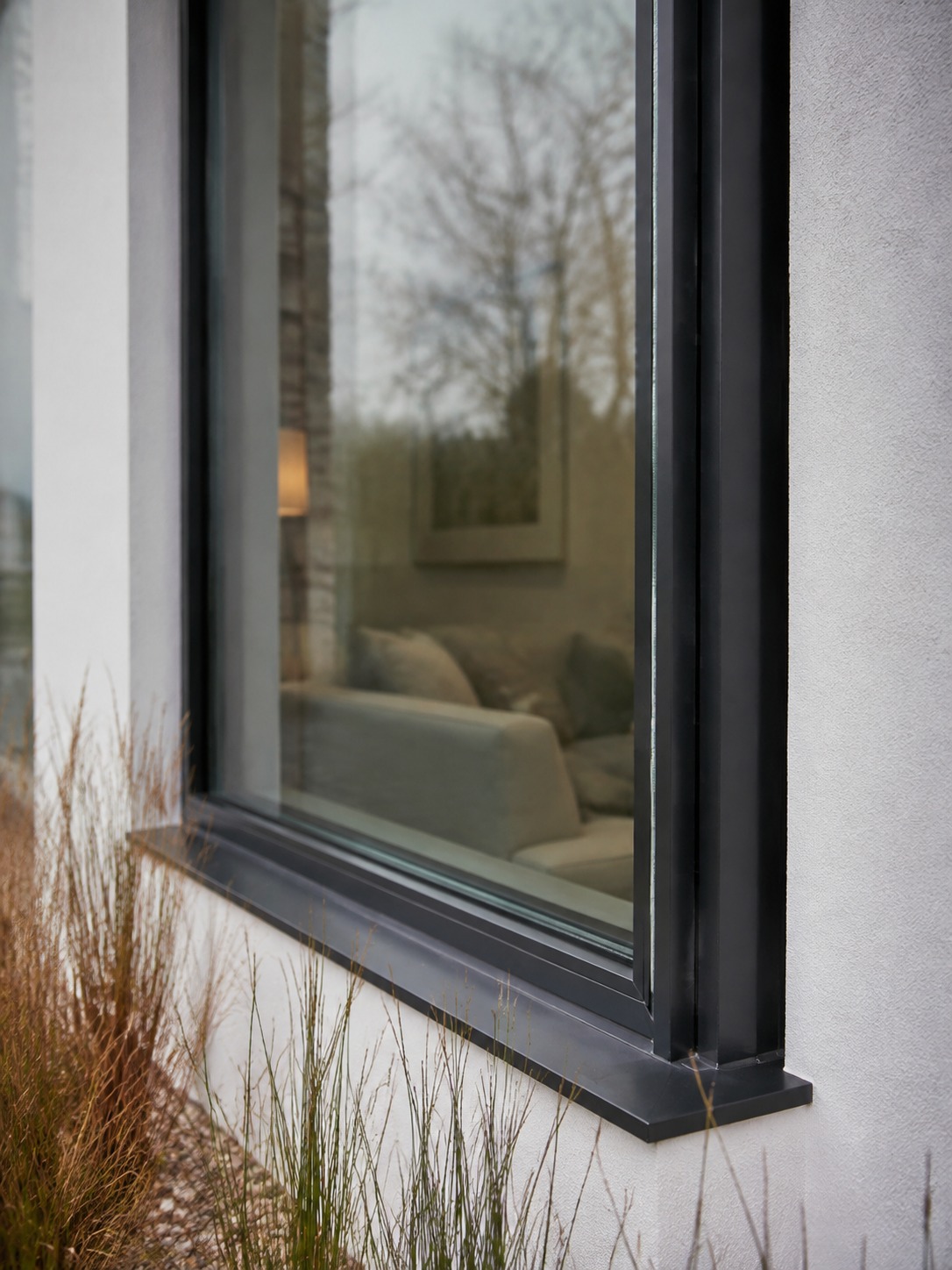 Window security film with slim black frame A modern black-framed window with subtle security film and low landscaping beneath the sill. | Sky Rye Design A modern black-framed window with subtle security film and low landscaping beneath the sill.
