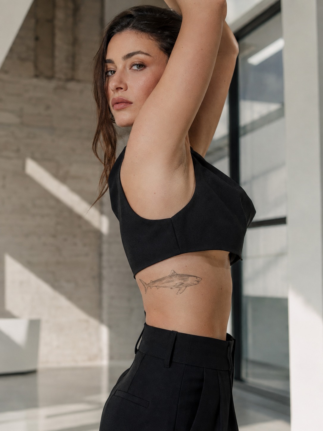 Model showing a fine-line tiger shark tattoo on the ribs with realistic healed ink and editorial lighting.