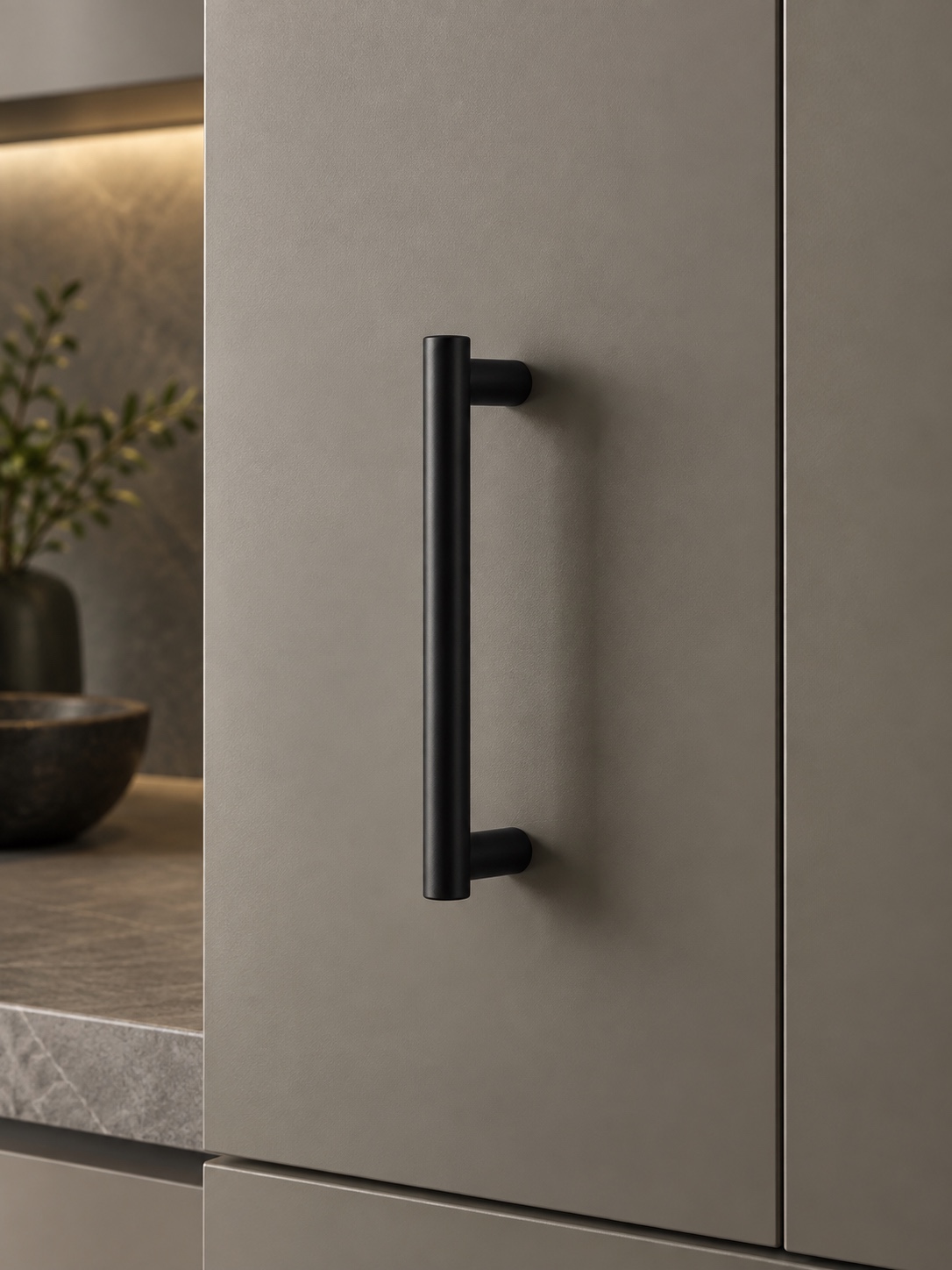 Matte black cabinet pull mounted on a modern flat cabinet door