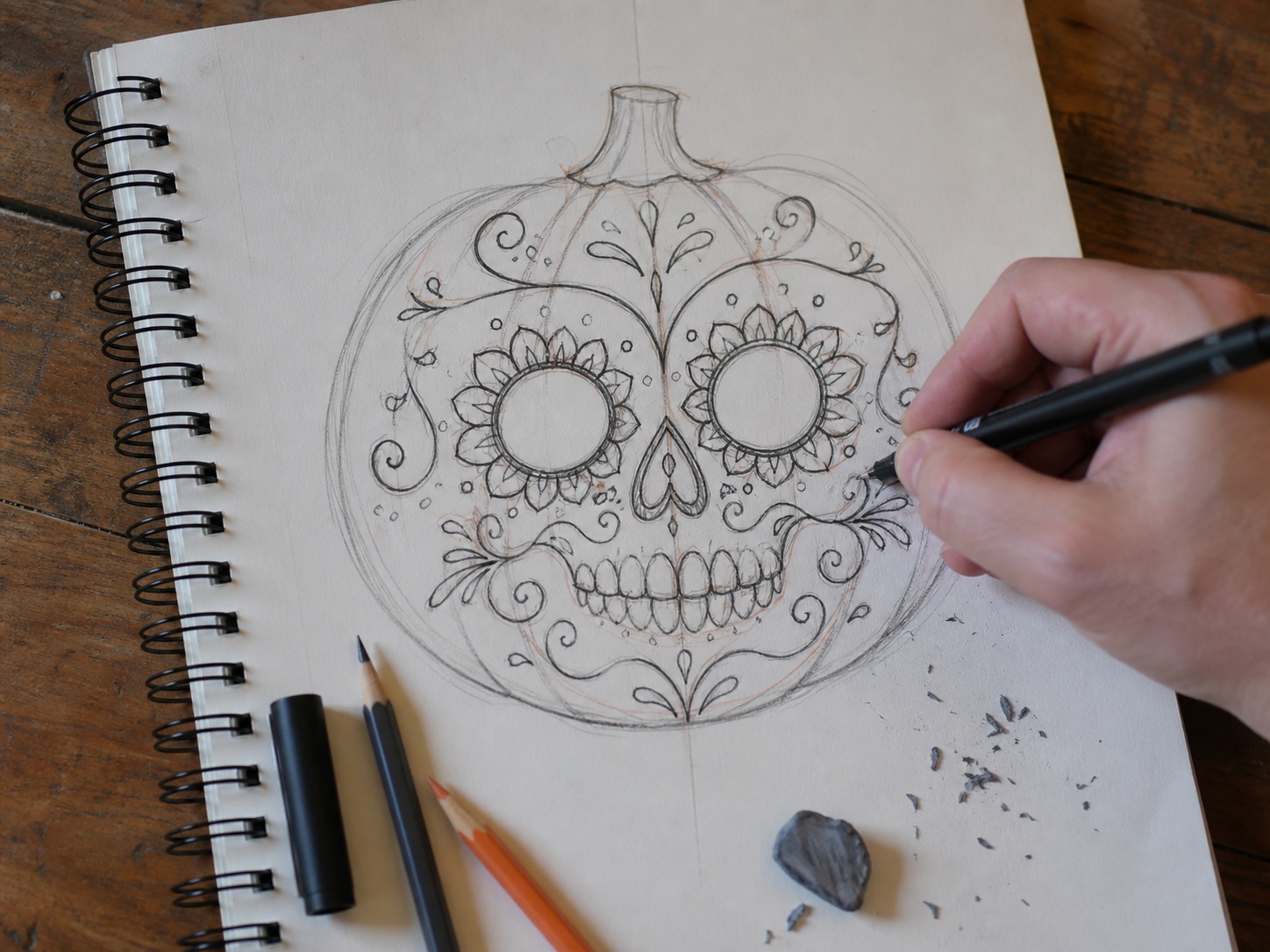 Sugar skull pumpkin drawing sketchbook Sugar skull pumpkin drawing sketchbook page with floral details, graphite underdrawing, and ink linework. | Sky Rye Design Sugar skull pumpkin drawing sketchbook page with floral details, graphite underdrawing, and ink linework.